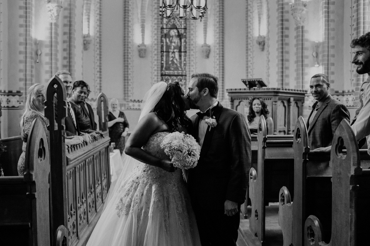Braut und Bräutigam küssen sich in der Kirche